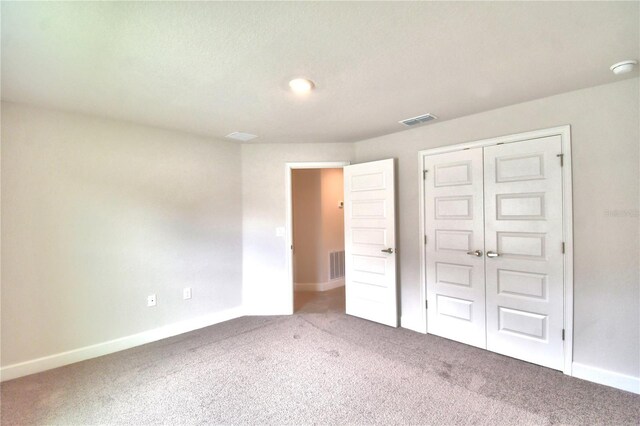 unfurnished bedroom with a closet and carpet floors