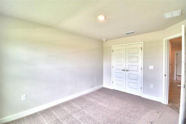 unfurnished bedroom with a closet and carpet