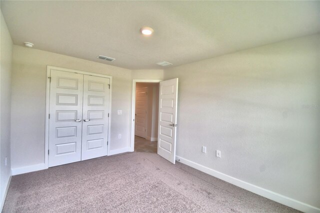 unfurnished bedroom with a closet and carpet