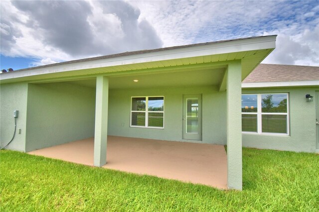 rear view of house with a yard and a patio