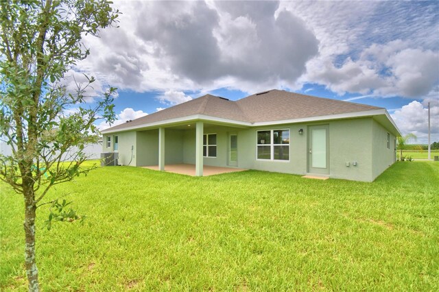 rear view of property with a lawn and a patio