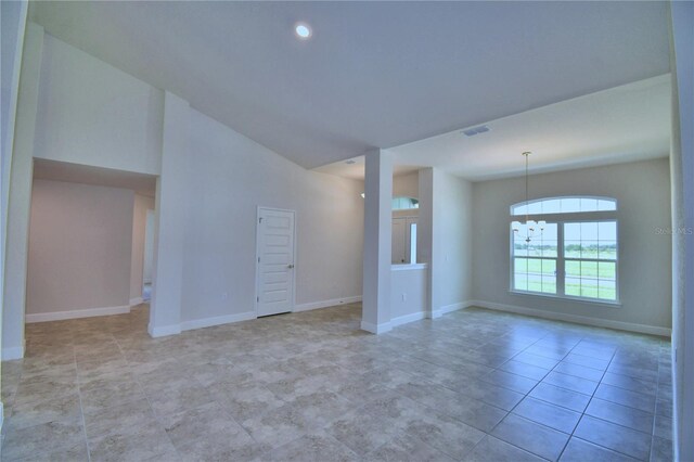 empty room with a notable chandelier and lofted ceiling