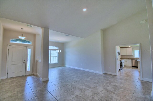 entrance foyer featuring a notable chandelier, light tile patterned floors, and plenty of natural light