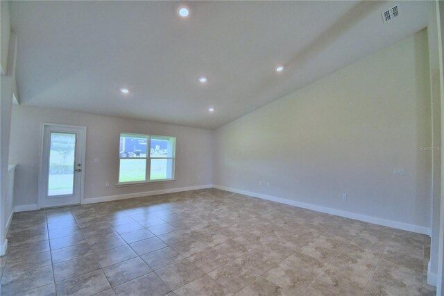 spare room featuring light tile patterned floors and lofted ceiling