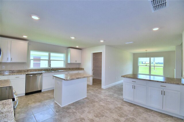 kitchen with pendant lighting, white cabinets, dishwasher, and a kitchen island