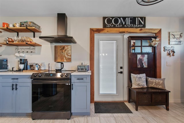 kitchen with range with electric stovetop, wall chimney range hood, gray cabinetry, and light tile floors