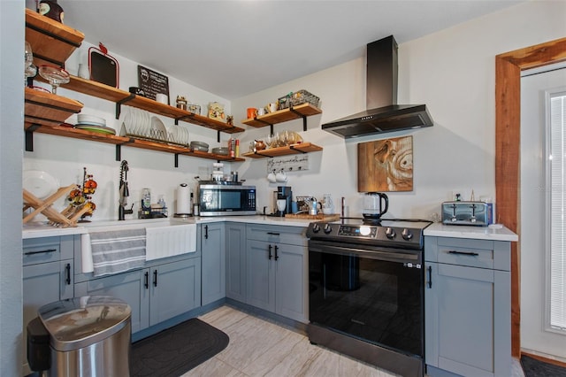 kitchen featuring light tile floors, stainless steel appliances, sink, and wall chimney range hood