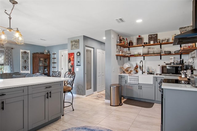 kitchen featuring gray cabinetry, pendant lighting, light tile floors, and sink