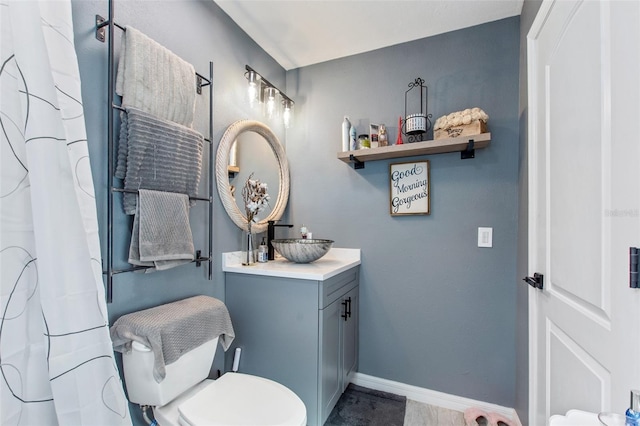 bathroom with toilet, tile flooring, and vanity