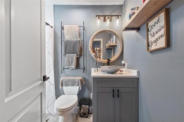 bathroom with toilet and vanity with extensive cabinet space