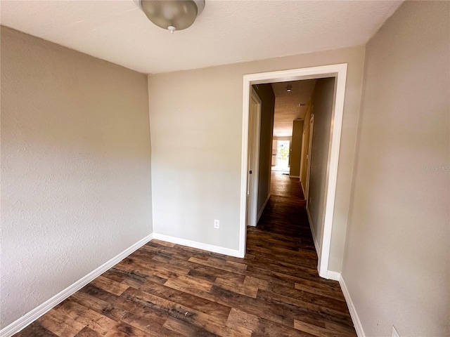 empty room with dark hardwood / wood-style flooring