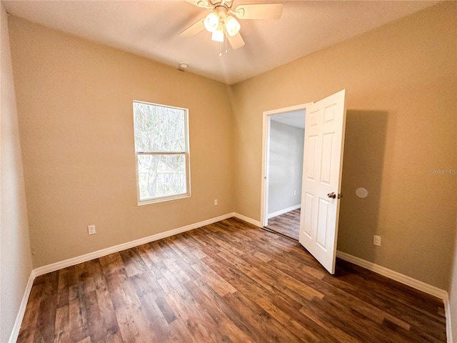 empty room featuring dark hardwood / wood-style flooring and ceiling fan