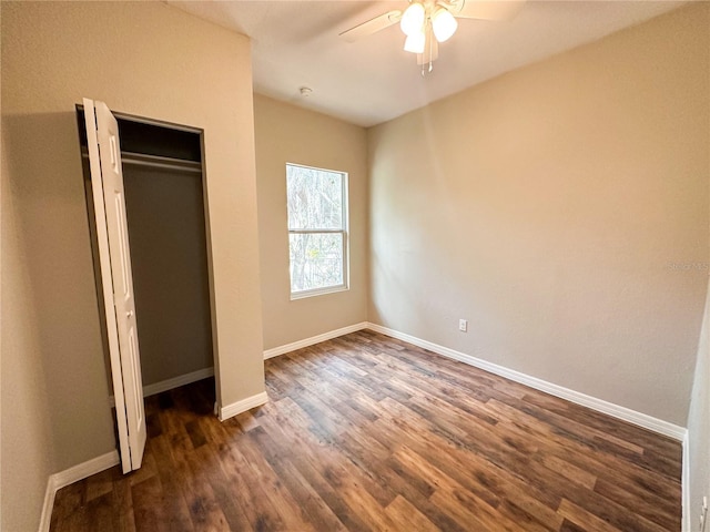 unfurnished bedroom with ceiling fan, a closet, and dark wood-type flooring