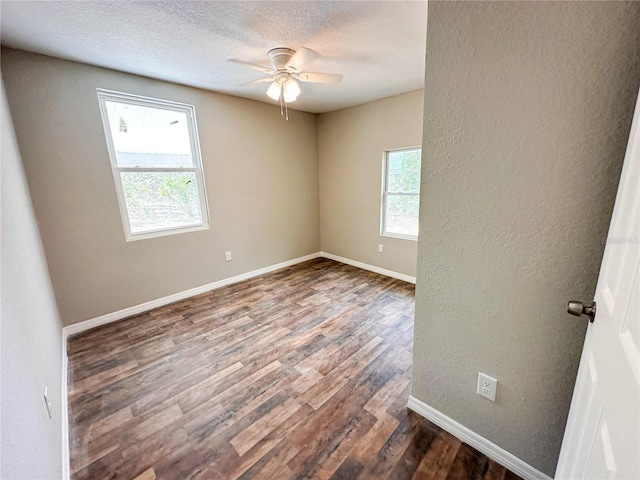 unfurnished room featuring a textured ceiling, dark hardwood / wood-style floors, ceiling fan, and a wealth of natural light