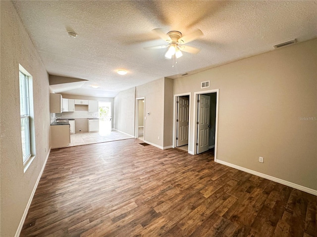 interior space featuring a textured ceiling, ceiling fan, and dark hardwood / wood-style floors