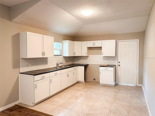 kitchen featuring tasteful backsplash, light hardwood / wood-style flooring, white cabinetry, and sink