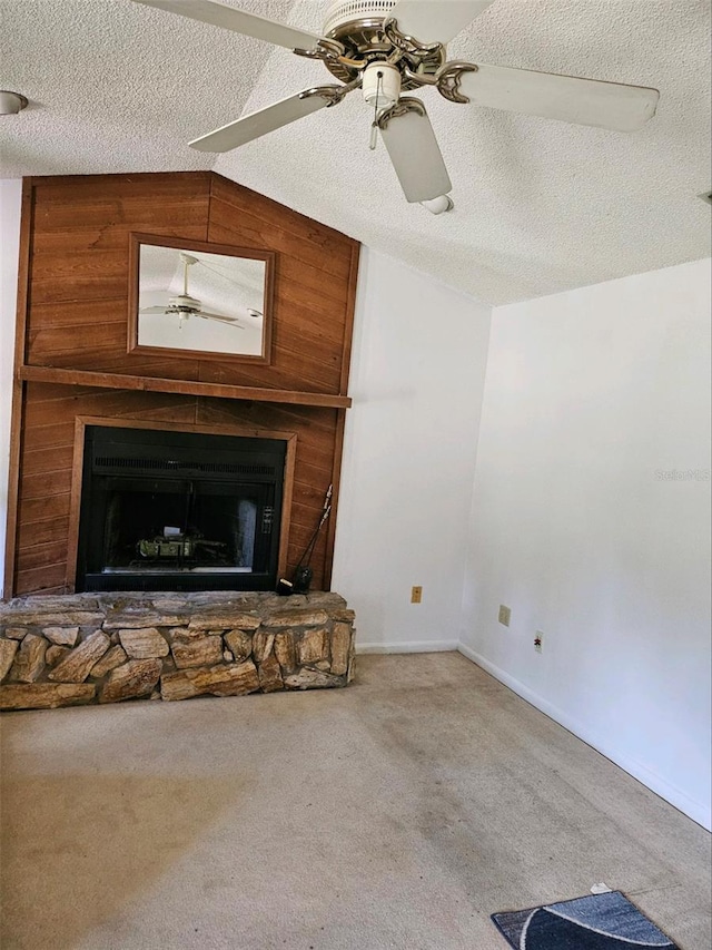 unfurnished living room featuring carpet flooring, a fireplace, a textured ceiling, vaulted ceiling, and wood walls