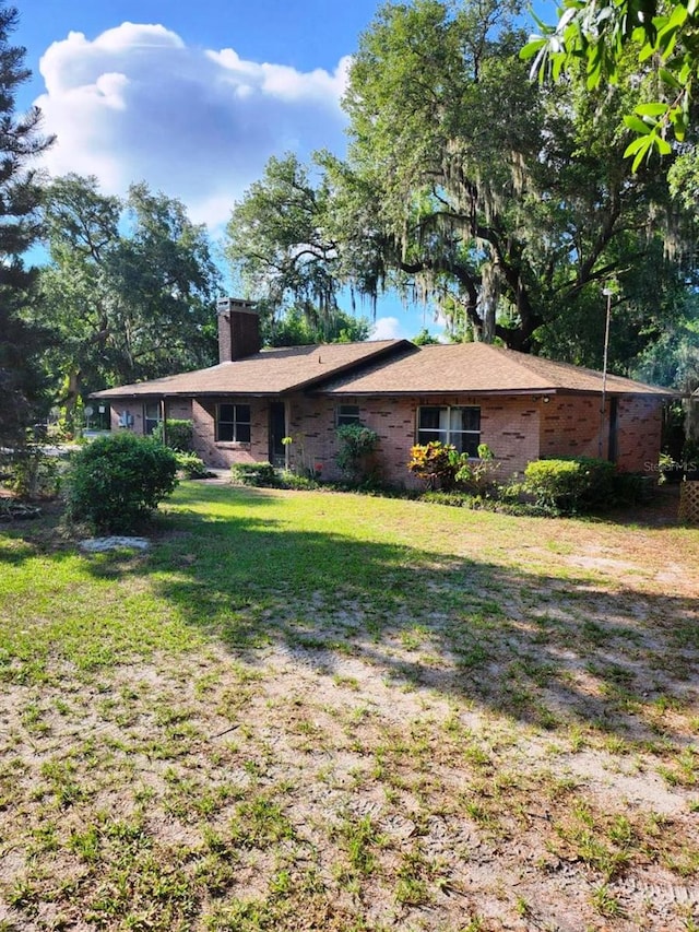 view of side of property with a lawn and a chimney