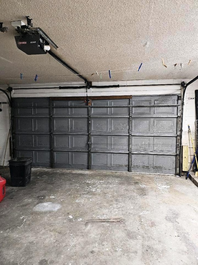 garage with concrete block wall and a garage door opener