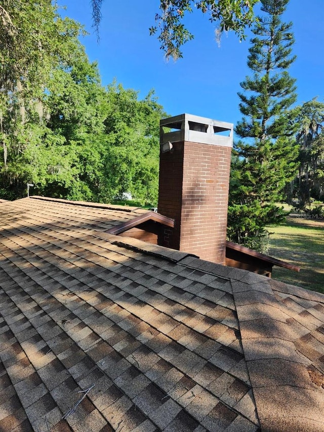 exterior details with roof with shingles and a chimney