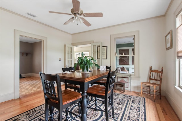 dining space featuring plenty of natural light, ornamental molding, ceiling fan, and light wood-type flooring