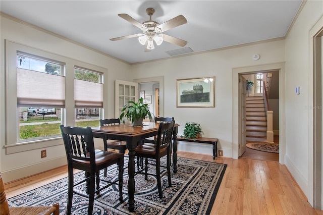 dining room with crown molding, a healthy amount of sunlight, ceiling fan, and light hardwood / wood-style flooring