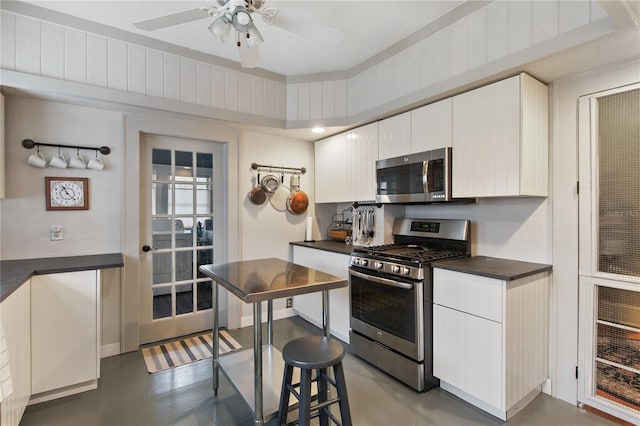 kitchen with appliances with stainless steel finishes, white cabinetry, and ceiling fan