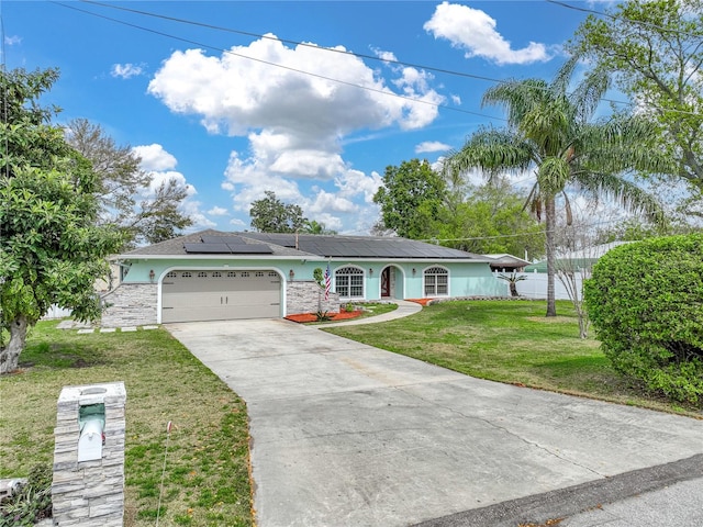 ranch-style home with a front yard, a garage, and solar panels