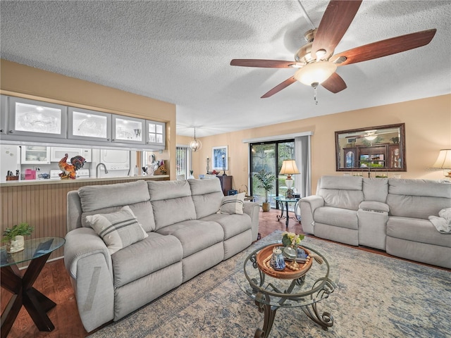 living room with hardwood / wood-style floors, ceiling fan, a textured ceiling, and sink