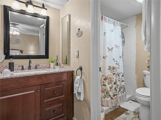 bathroom featuring toilet, ceiling fan, a textured ceiling, vanity, and tile flooring