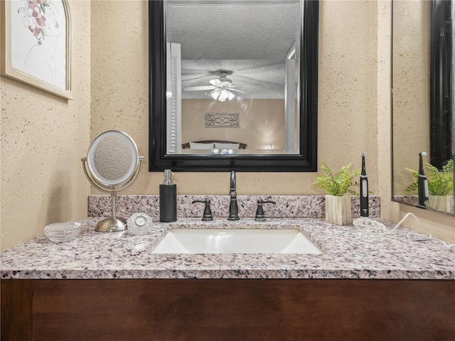 interior space featuring a textured ceiling, vanity, and ceiling fan