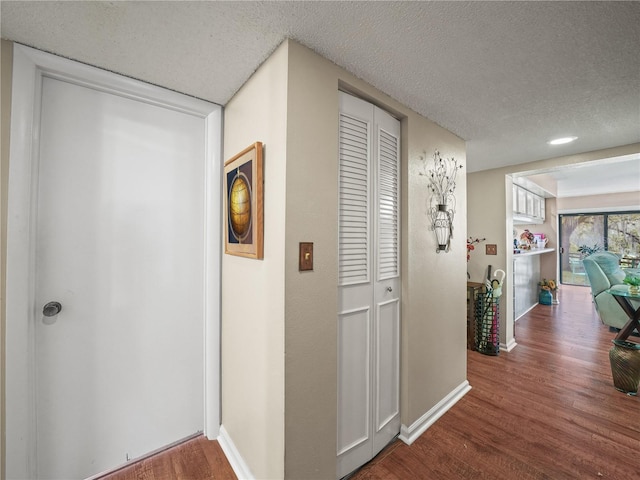 hall featuring dark hardwood / wood-style floors and a textured ceiling