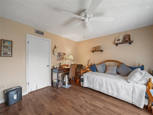 bedroom with dark hardwood / wood-style floors, a textured ceiling, and ceiling fan