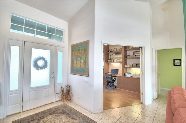 entryway featuring high vaulted ceiling and light tile floors