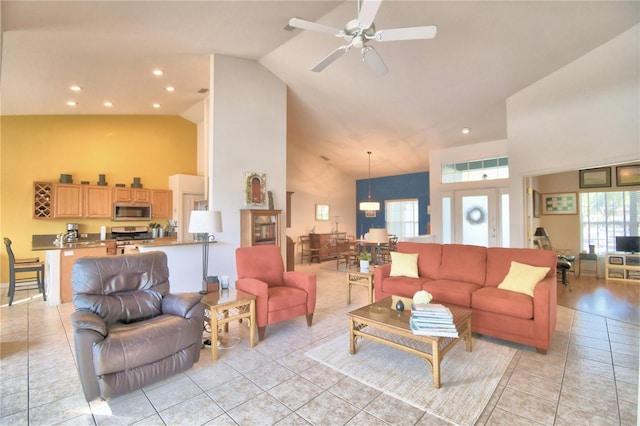 living room with high vaulted ceiling, ceiling fan, and light tile flooring