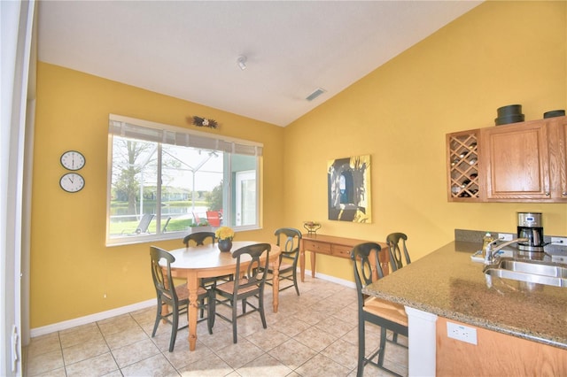 dining room with light tile flooring, vaulted ceiling, and sink