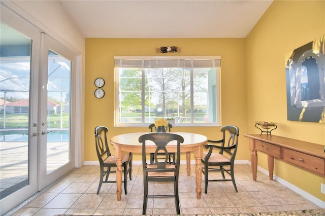 tiled dining room featuring plenty of natural light and french doors