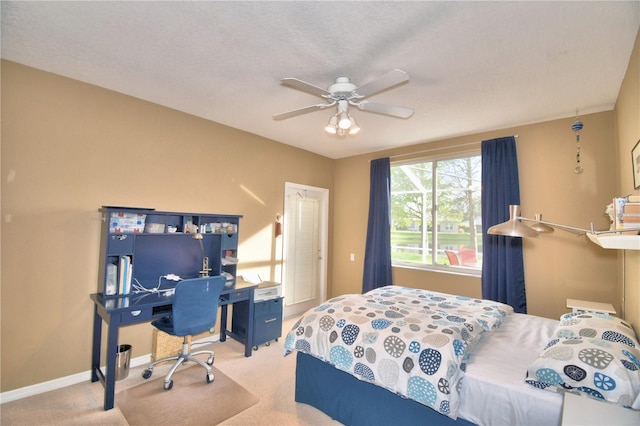 bedroom with light carpet, a textured ceiling, and ceiling fan