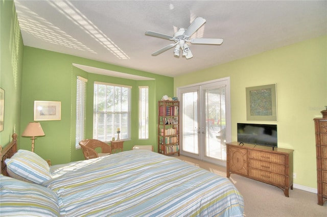 bedroom with access to exterior, ceiling fan, multiple windows, and french doors