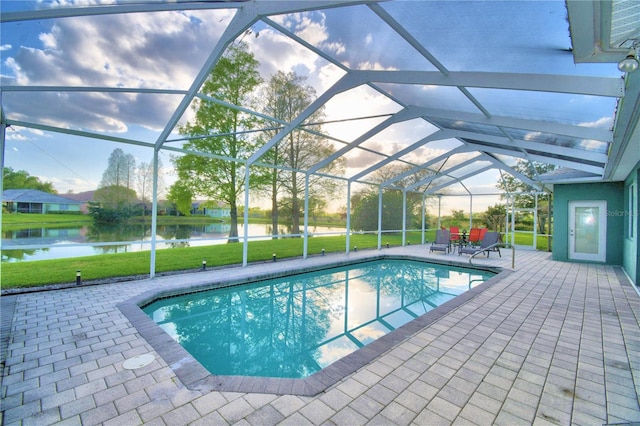 view of swimming pool featuring glass enclosure, a lawn, and a patio area