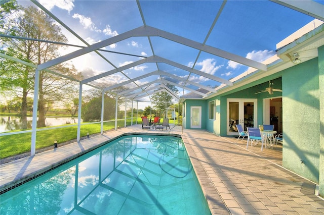 view of pool featuring glass enclosure, a yard, and a patio