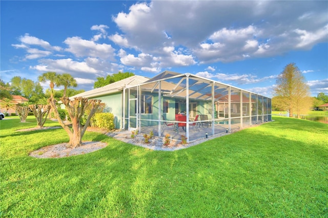 rear view of house with a swimming pool, a patio, glass enclosure, and a yard