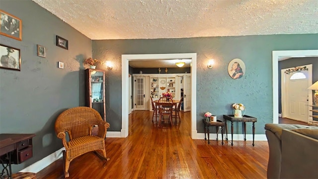 living area with dark hardwood / wood-style floors and a textured ceiling