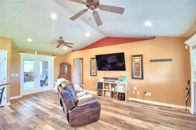 living room with ceiling fan, hardwood / wood-style flooring, lofted ceiling, and french doors