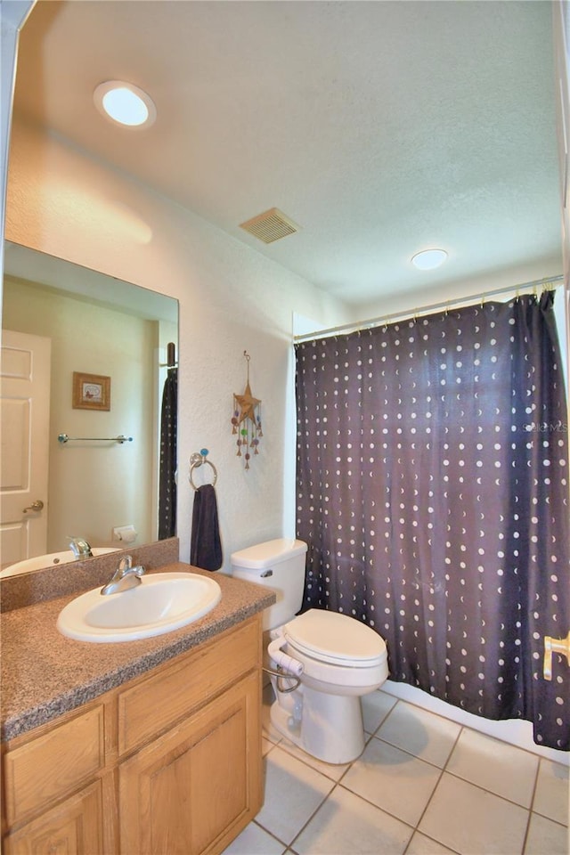 bathroom with tile patterned flooring, curtained shower, vanity, and toilet