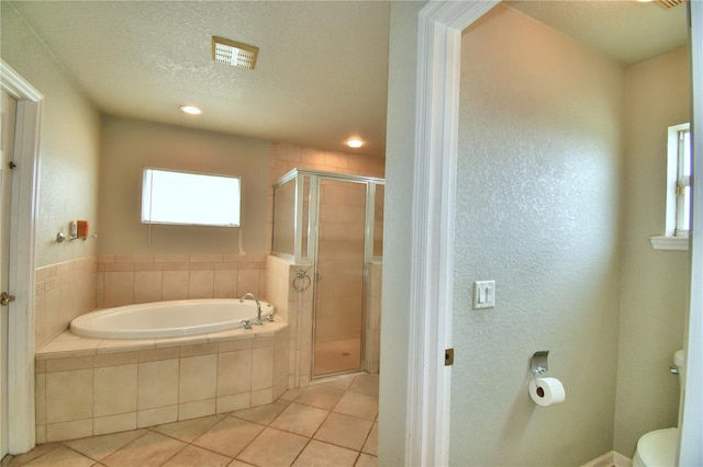 bathroom featuring independent shower and bath, a textured ceiling, toilet, and tile patterned floors