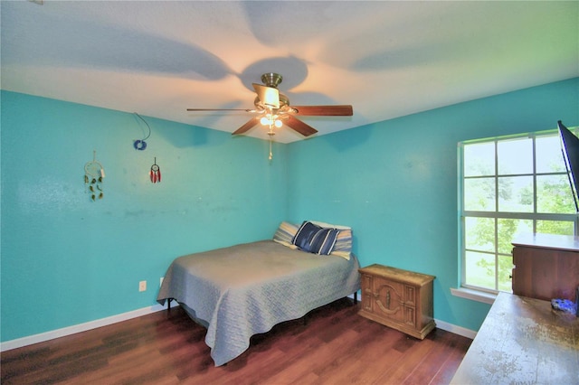 bedroom featuring ceiling fan, dark hardwood / wood-style floors, and multiple windows