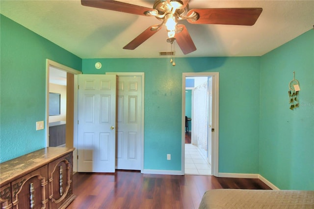 bedroom with a closet, ceiling fan, and dark hardwood / wood-style floors