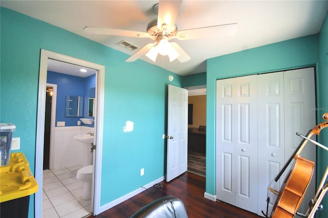 bedroom featuring ceiling fan, a closet, hardwood / wood-style floors, and ensuite bathroom