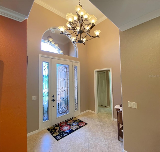 entryway with a notable chandelier, light tile patterned floors, and ornamental molding